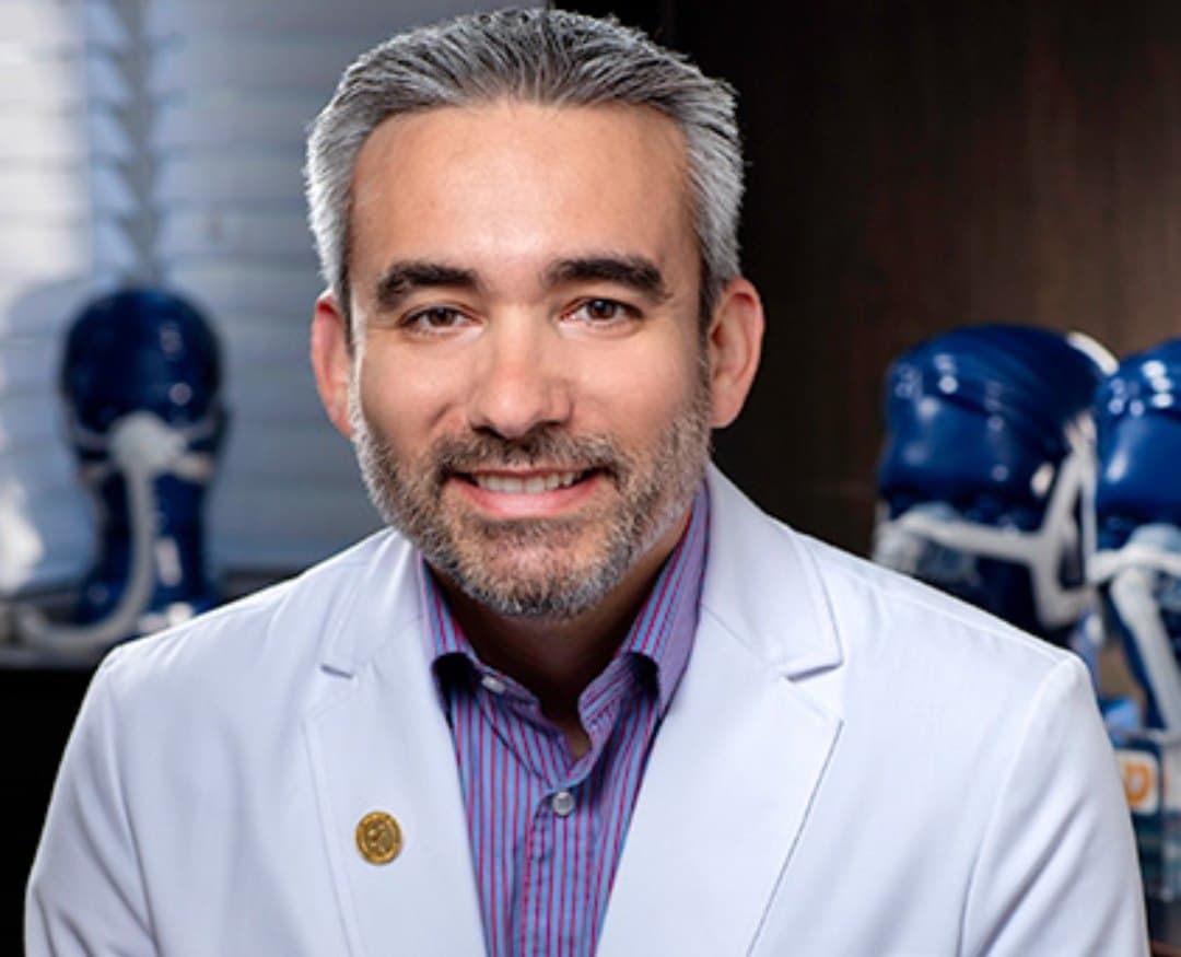 Dr. Camilo Ruiz in his white coat at the office
