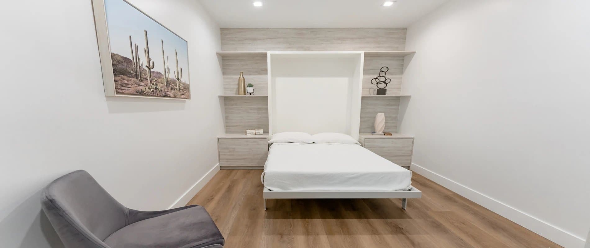 Private sleep study bedroom with a made bed, shelves and an armchair