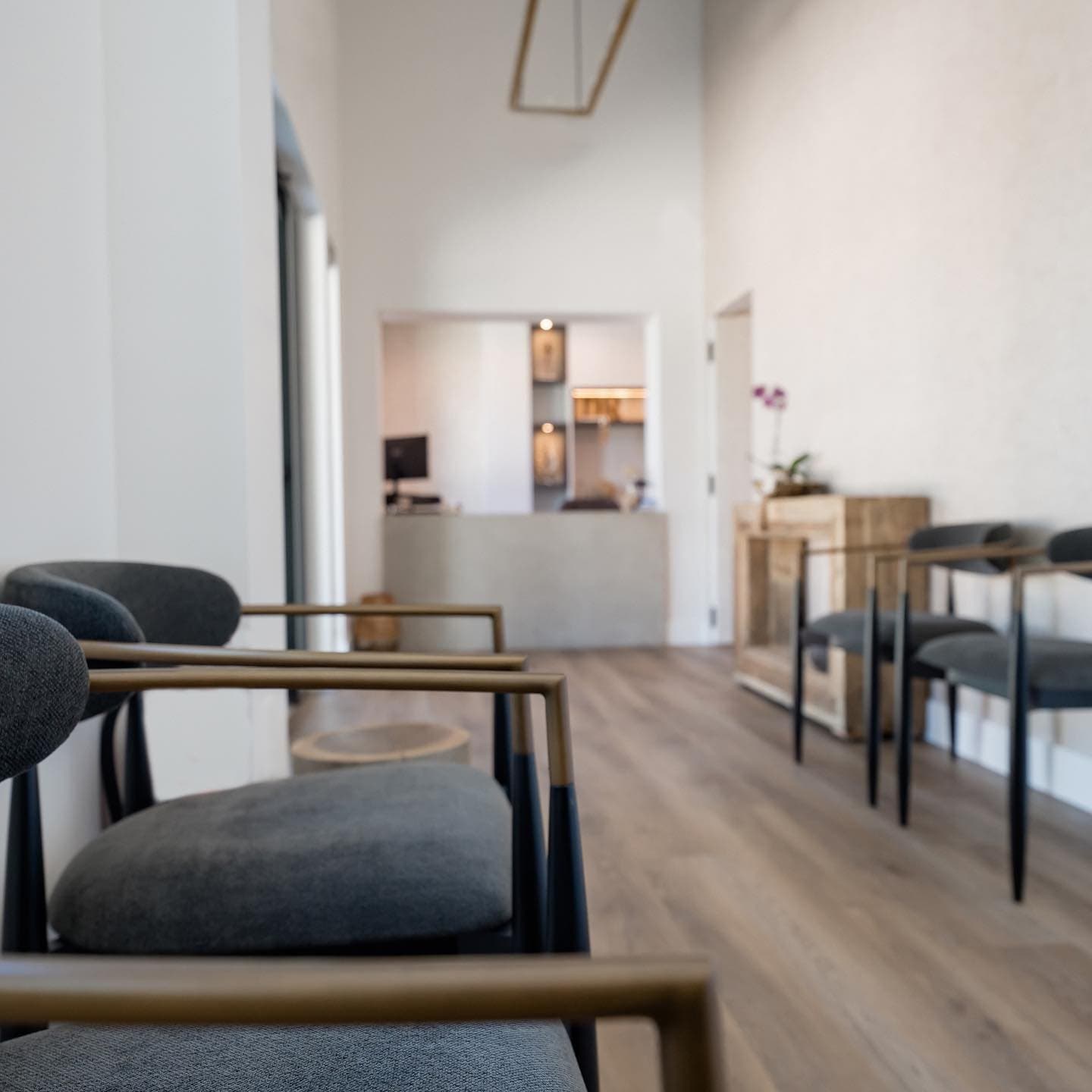 Bright waiting room with upholstered chairs and wood floors